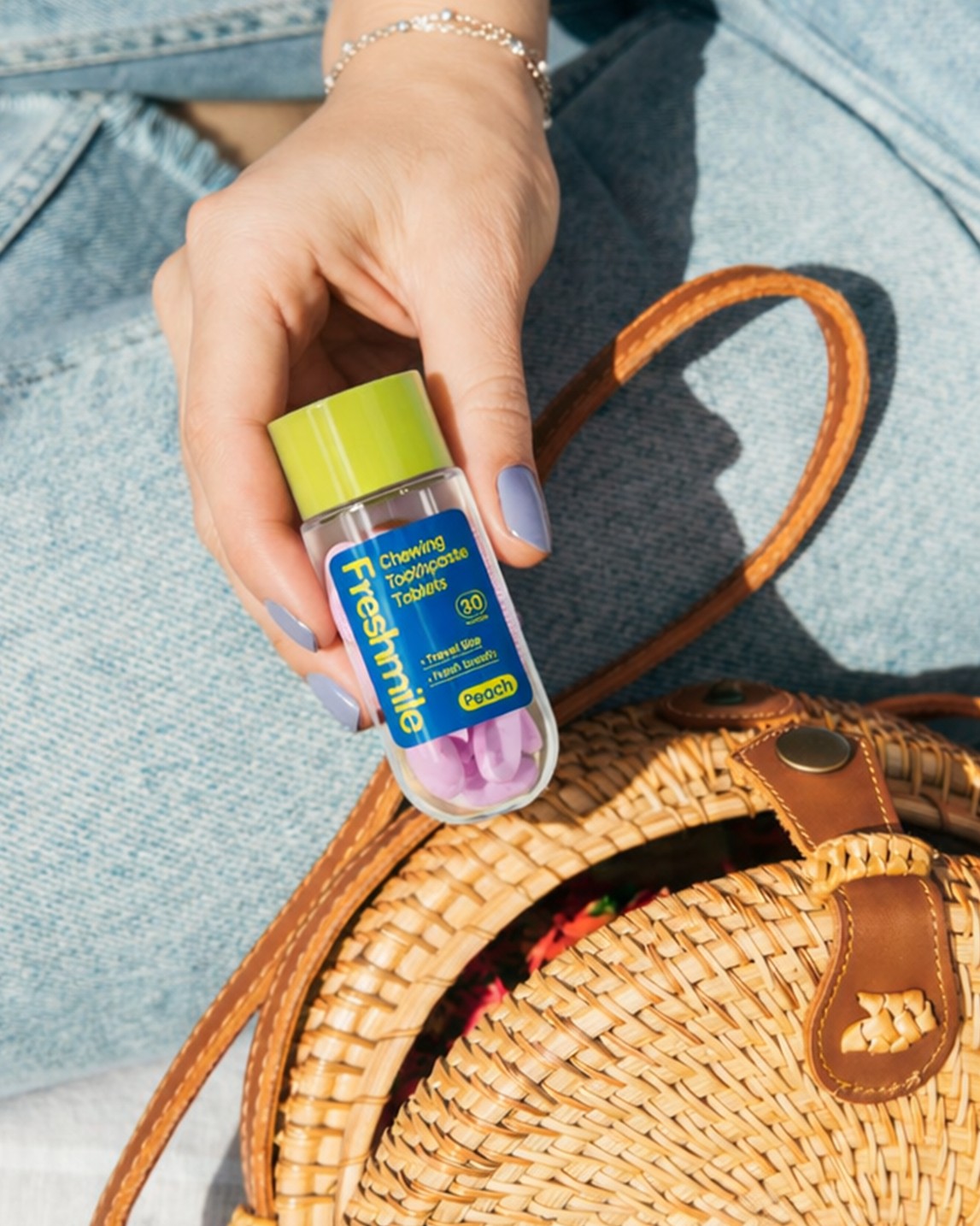 Hand pulling Freshmile toothpaste tablets from a woven bag