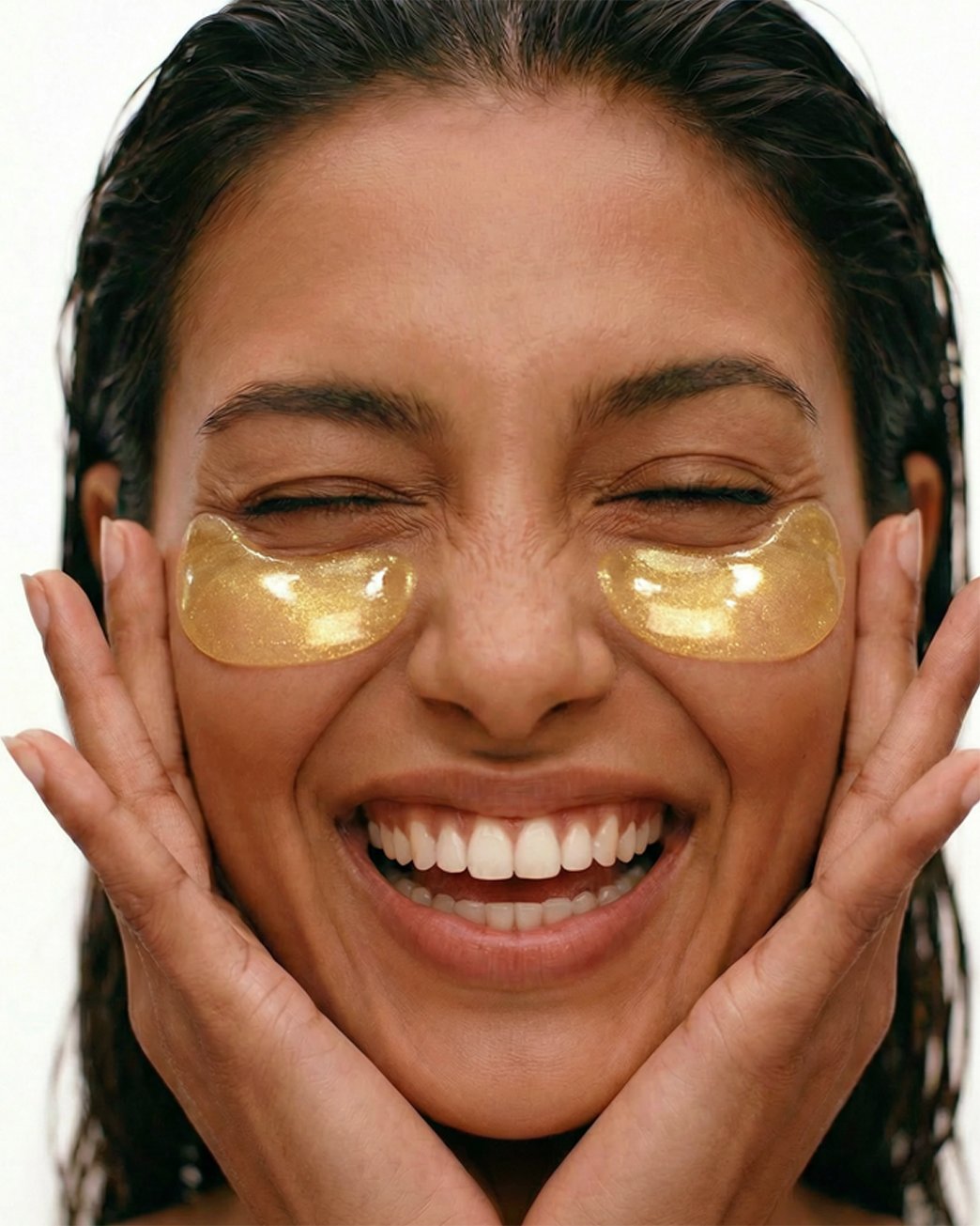 Woman applying golden eye patches